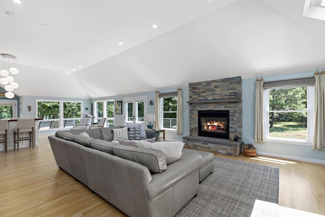 living area featuring light wood-style floors, lofted ceiling, and a healthy amount of sunlight