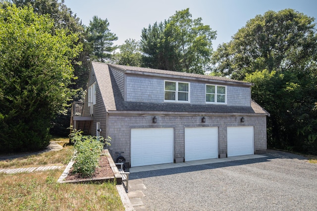 view of front of property featuring a garage and roof with shingles