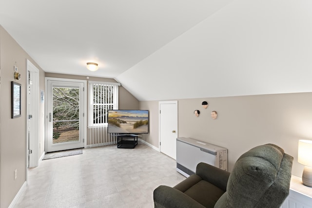 living area featuring lofted ceiling, heating unit, and baseboards