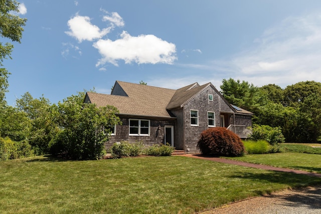 shingle-style home with a front lawn and a shingled roof