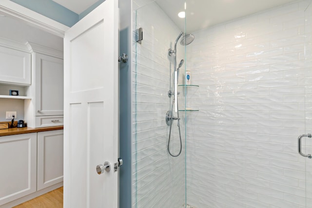 full bathroom featuring a shower stall and wood finished floors