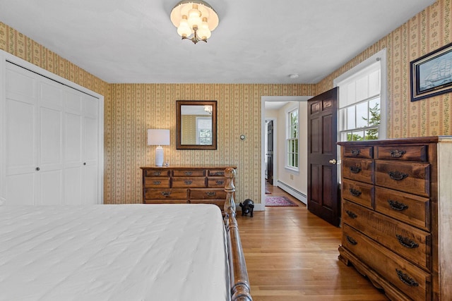 10 Briarfield Rd, South Dennis, MA 02660 - bedroom featuring wallpapered walls, a baseboard radiator, wood finished floors, and a closet