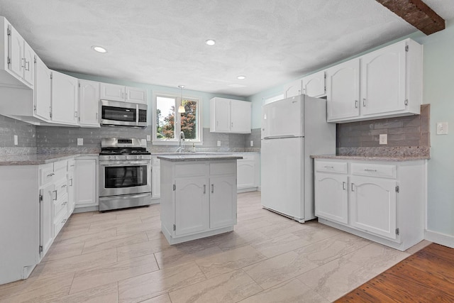 10 Briarfield Rd, South Dennis, MA 02660 - kitchen featuring appliances with stainless steel finishes, decorative backsplash, white cabinets, recessed lighting, and light stone countertops
