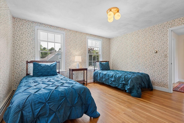 10 Briarfield Rd, South Dennis, MA 02660 - bedroom with wallpapered walls, a baseboard radiator, and wood finished floors
