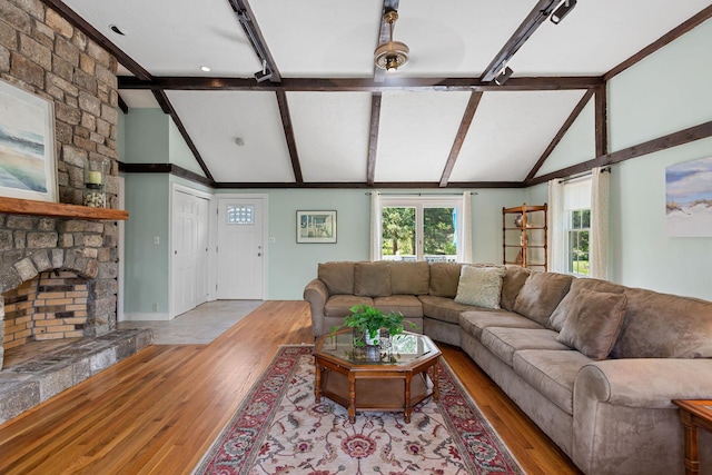 10 Briarfield Rd, South Dennis, MA 02660 - living room featuring wood finished floors, beamed ceiling, high vaulted ceiling, and a stone fireplace