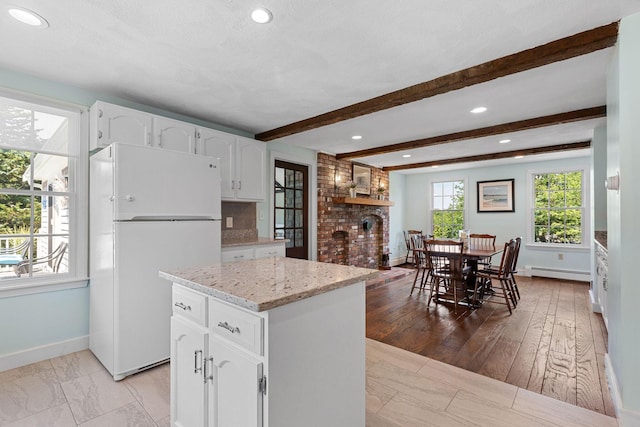 10 Briarfield Rd, South Dennis, MA 02660 - kitchen featuring freestanding refrigerator, light stone countertops, white cabinetry, baseboard heating, and beamed ceiling