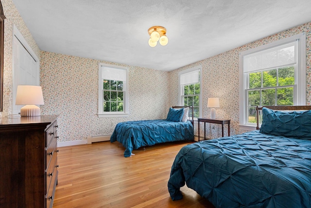 10 Briarfield Rd, South Dennis, MA 02660 - bedroom featuring wallpapered walls, light wood-type flooring, and a baseboard heating unit