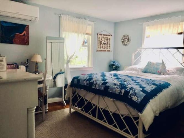 5 Greyhampton Rd, West Yarmouth, MA 02673 - bedroom with an AC wall unit, multiple windows, and wood finished floors