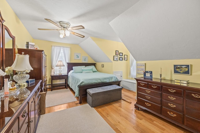 bedroom with vaulted ceiling, light wood finished floors, and ceiling fan