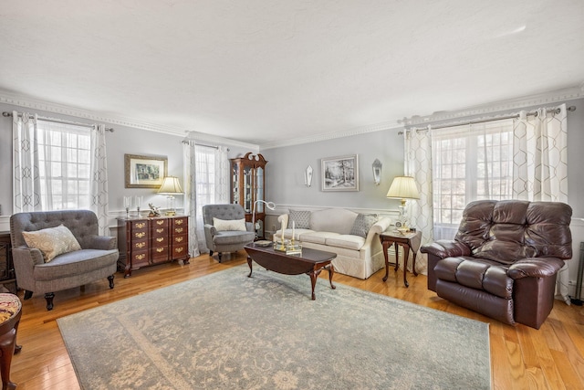 living area featuring wood finished floors and crown molding