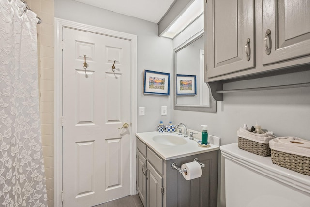 bathroom featuring toilet, curtained shower, and vanity