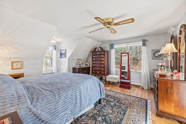 bedroom with ceiling fan, vaulted ceiling, and wood finished floors