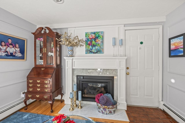 living room featuring dark wood-type flooring, a baseboard radiator, and a fireplace