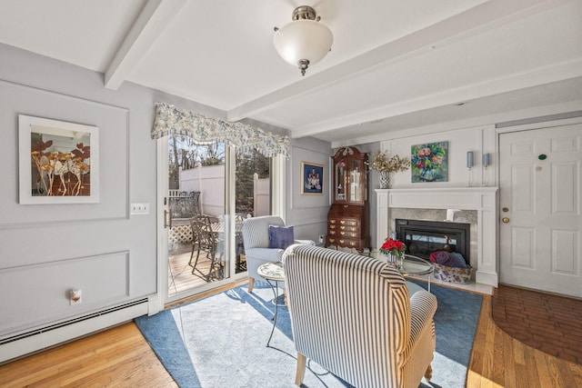 living room featuring a premium fireplace, a baseboard heating unit, beam ceiling, and wood finished floors