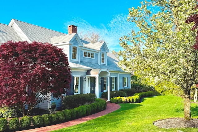 view of front of house featuring a chimney and a front lawn