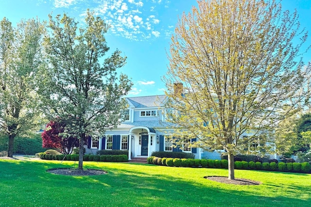 view of front of house with a front yard and a chimney
