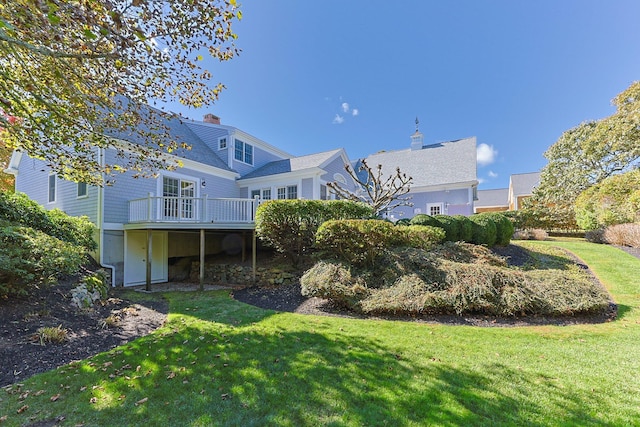 back of house with a lawn and a deck