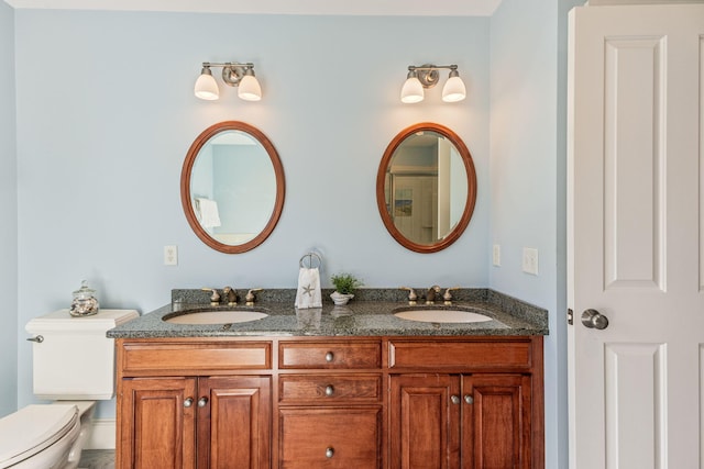 bathroom with toilet and double vanity