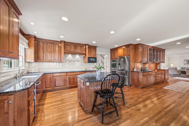 kitchen with a kitchen island, sink, dark stone countertops, and appliances with stainless steel finishes