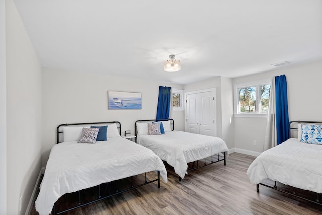 bedroom with wood-type flooring and a closet