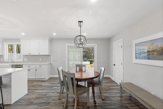 dining area with a notable chandelier and dark hardwood / wood-style flooring