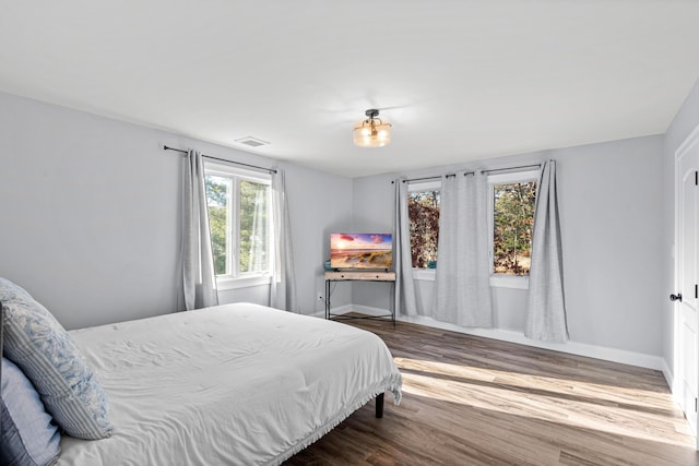 bedroom with dark hardwood / wood-style flooring