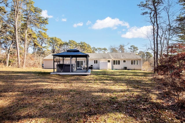 back of property with a lawn and a gazebo