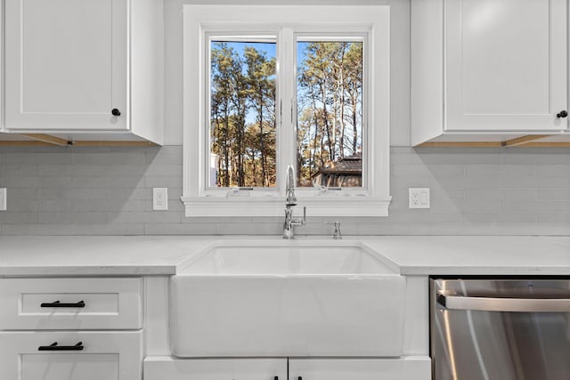 kitchen featuring sink, dishwasher, white cabinetry, and light stone counters