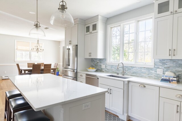 331 Riverview Dr, Chatham, MA 02633 - kitchen with appliances with stainless steel finishes, a sink, tasteful backsplash, a center island, and a breakfast bar