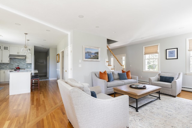 331 Riverview Dr, Chatham, MA 02633 - living area with a baseboard heating unit, stairway, light wood-style floors, and baseboards