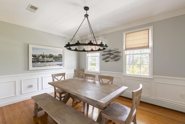331 Riverview Dr, Chatham, MA 02633 - dining space featuring a chandelier, ornamental molding, a wainscoted wall, wood finished floors, and a decorative wall