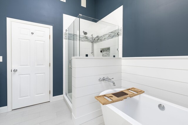 331 Riverview Dr, Chatham, MA 02633 - bathroom featuring a soaking tub, a shower stall, tile patterned floors, and baseboards