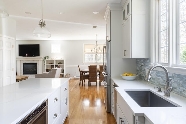 331 Riverview Dr, Chatham, MA 02633 - kitchen with a sink, tasteful backsplash, pendant lighting, and white cabinets
