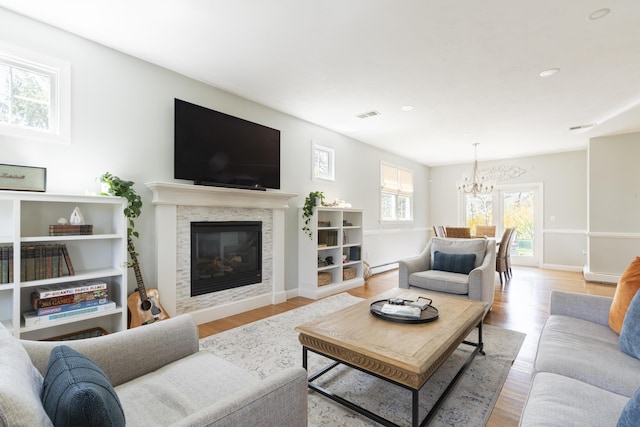 331 Riverview Dr, Chatham, MA 02633 - living area with a chandelier, light wood finished floors, a glass covered fireplace, a baseboard heating unit, and recessed lighting