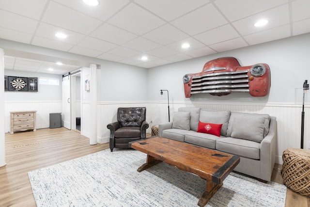 331 Riverview Dr, Chatham, MA 02633 - living room with a barn door, wood finished floors, wainscoting, and a drop ceiling