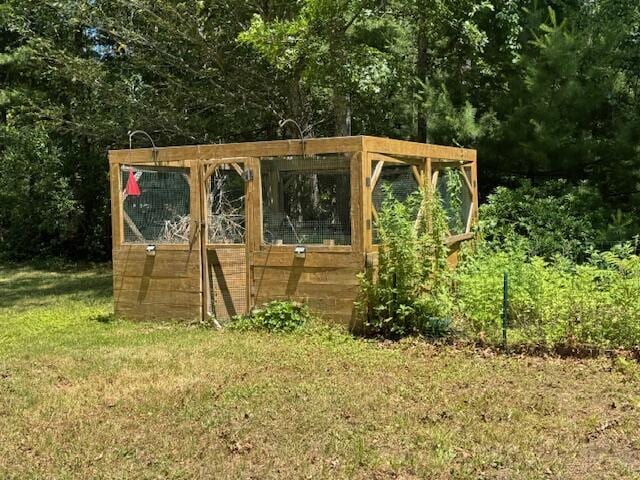157 Mockingbird Ln, Marstons Mills, MA 02648 - view of grassy yard with exterior structure, an outdoor structure, and a forest view