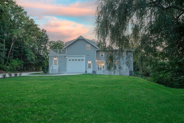 view of front of home with a balcony, an attached garage, and a front lawn