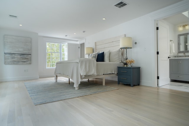 bedroom featuring light wood-type flooring, visible vents, and baseboards