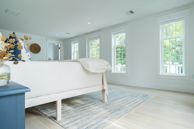 bedroom featuring multiple windows, wood finished floors, and visible vents