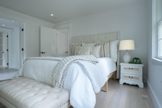 bedroom with visible vents, baseboards, light wood-style flooring, and recessed lighting