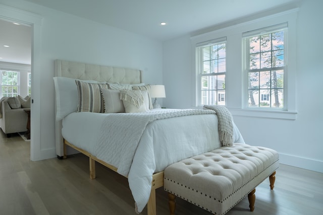 bedroom with baseboards, wood finished floors, and recessed lighting