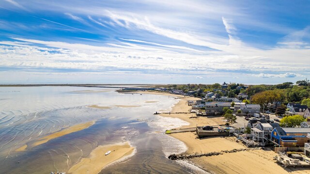 drone / aerial view with a water view and a beach view