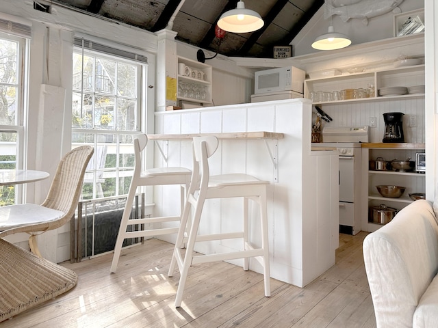 interior space featuring light wood-type flooring, white appliances, and lofted ceiling