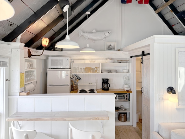 kitchen with decorative light fixtures, a barn door, vaulted ceiling with beams, and fridge