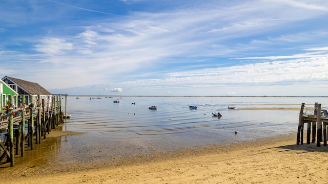 dock area featuring a water view and a view of the beach