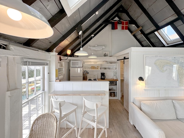 kitchen featuring light wood-type flooring, fridge, wooden ceiling, lofted ceiling with skylight, and a barn door