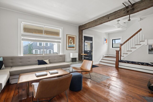 living room featuring baseboard heating, hardwood / wood-style floors, ornamental molding, and beamed ceiling