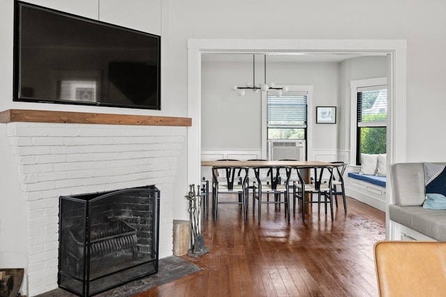 living room featuring a notable chandelier, cooling unit, a fireplace, and dark hardwood / wood-style flooring