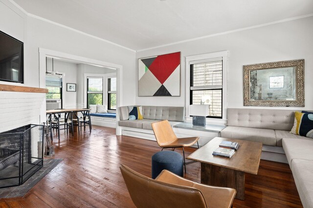 living room with crown molding, dark hardwood / wood-style floors, and a fireplace