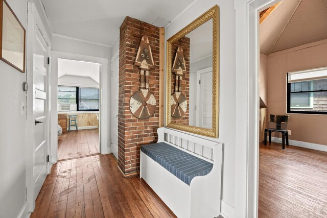 corridor featuring crown molding, hardwood / wood-style floors, and vaulted ceiling